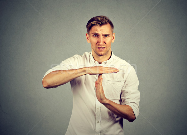 Young angry man showing time out hand gesture  Stock photo © ichiosea