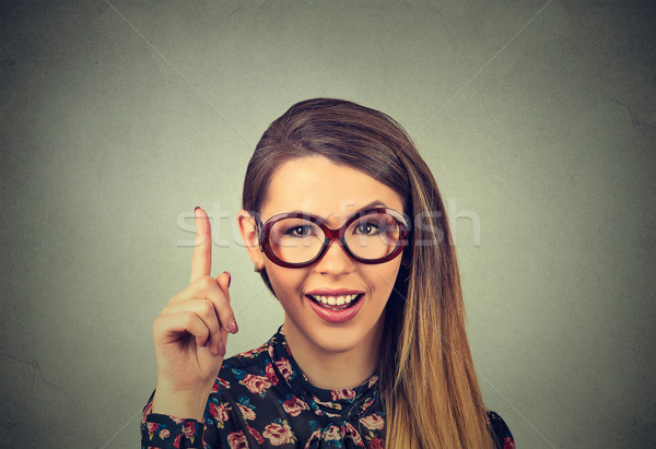 young woman has idea, pointing with finger up Stock photo © ichiosea