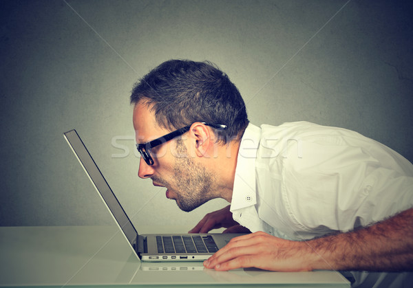 Side profile man staring closely intensely at laptop screen  Stock photo © ichiosea