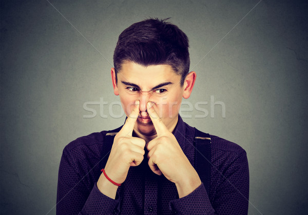man pinches nose looks with disgust something stinks bad smell  Stock photo © ichiosea