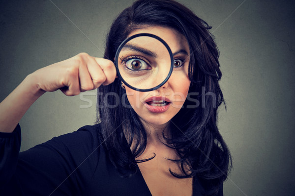Surprised woman looking through magnifying glass  Stock photo © ichiosea