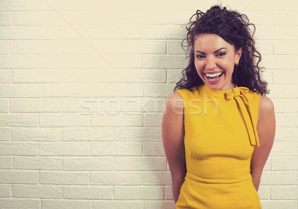 Happy girl laughing against a white brick wall background. Stock photo © ichiosea