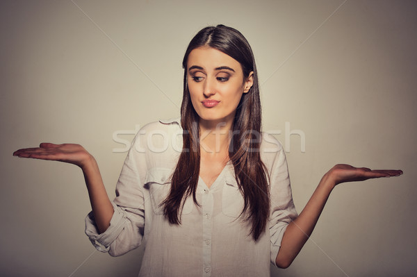 Stock photo: perplexed looking woman arms out shrugs shoulders I don't know can't make a choice