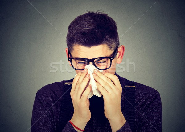 Man in glasses sneezing in a tissue blowing runny nose Stock photo © ichiosea
