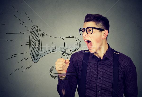 Angry young man screaming in megaphone  Stock photo © ichiosea