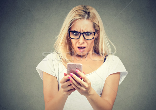 Shocked woman looking at mobile phone Stock photo © ichiosea