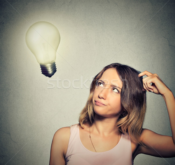 girl thinks looking up at bright light bulb Stock photo © ichiosea