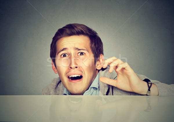 Funny scared man peeking from behind the desk  Stock photo © ichiosea