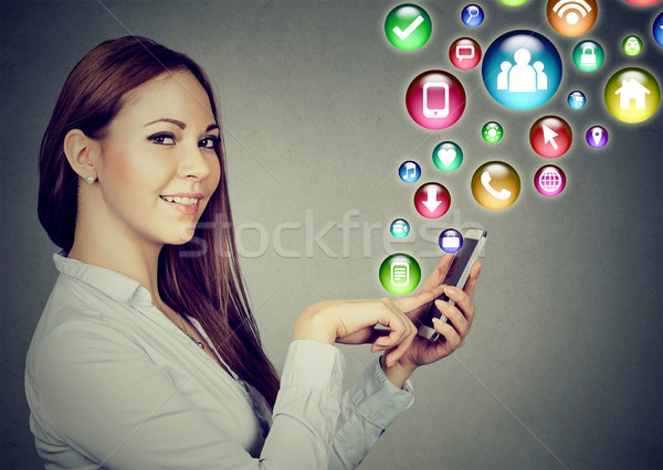 Woman using smartphone with social media application icons flying out  Stock photo © ichiosea