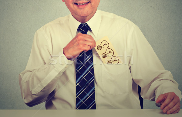 Stock photo: businessman with idea withdrawing card with hand drawn light bulb from shirt pocket
