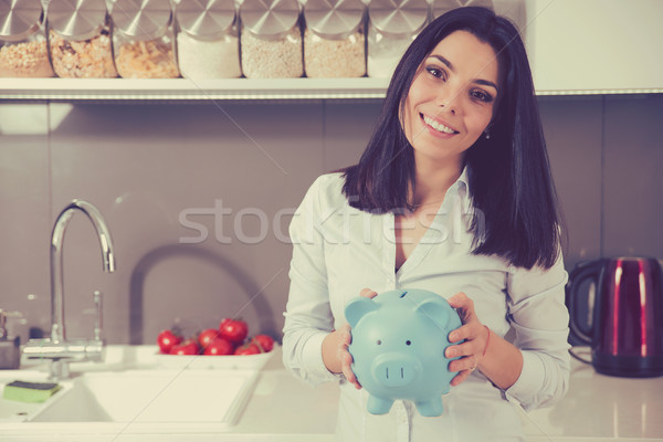 Happy woman with piggy bank in her new apartment home  Stock photo © ichiosea