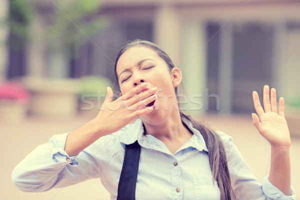 Stock photo: sleepy young business woman covering with hand opened mouth yawning 