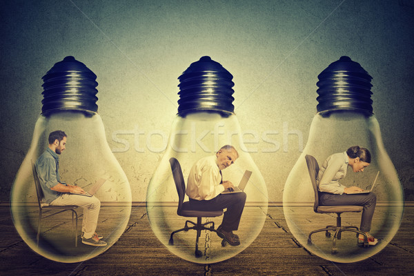 company employees sitting in row inside electric lamp using working on computer Stock photo © ichiosea