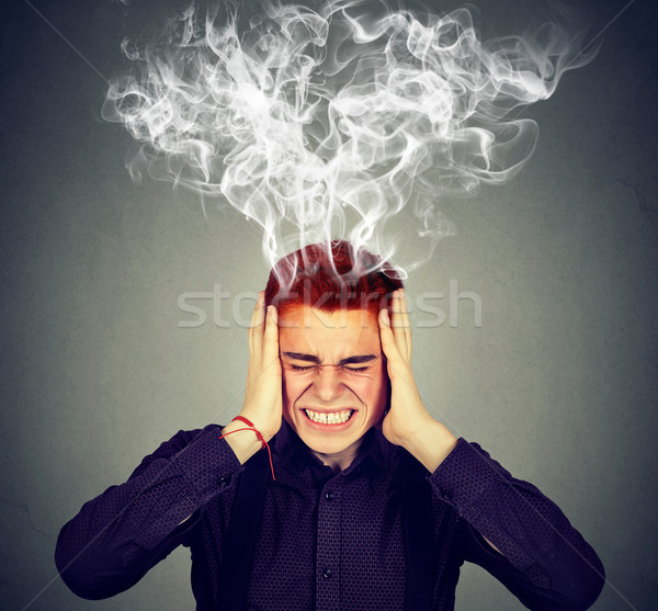 Stressed man thinks very intensely having headache  Stock photo © ichiosea