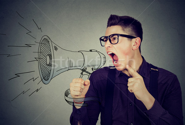 Angry young man screaming in megaphone  Stock photo © ichiosea