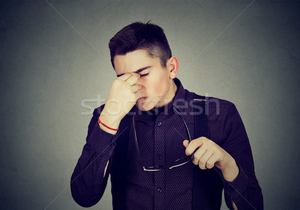 Man with glasses rubbing his eyes feels tired  Stock photo © ichiosea