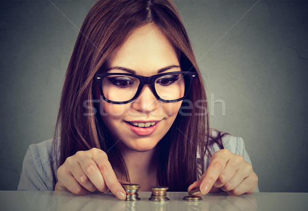Young woman counting money stacking up coins   Stock photo © ichiosea