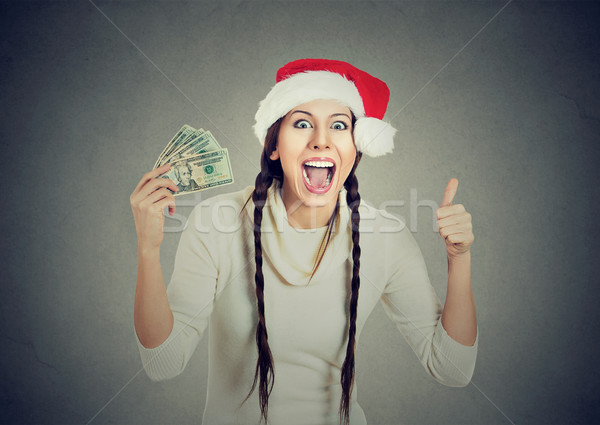 Woman in santa hat with dollar bills showing thumb up Stock photo © ichiosea