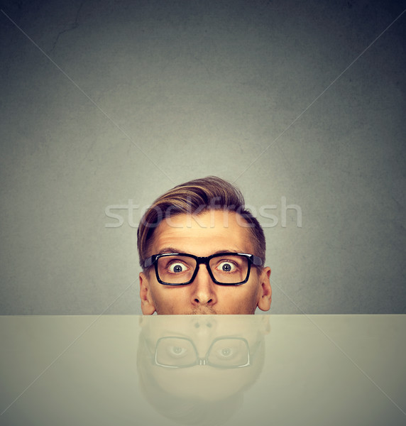 surprised businessman peeking from under the table  Stock photo © ichiosea