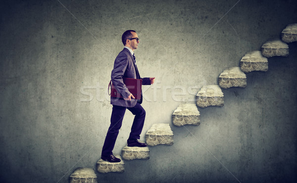 Businessman with briefcase stepping up a stairway career ladder  Stock photo © ichiosea
