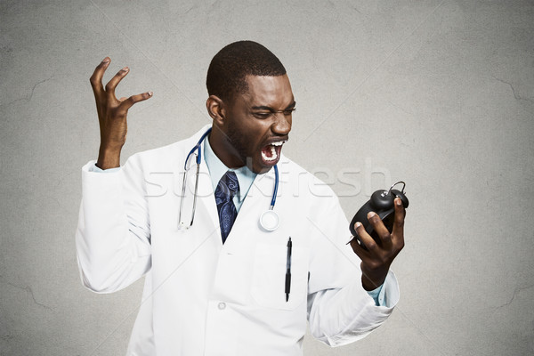 Stock photo: Stressed doctor, holding alarm clock