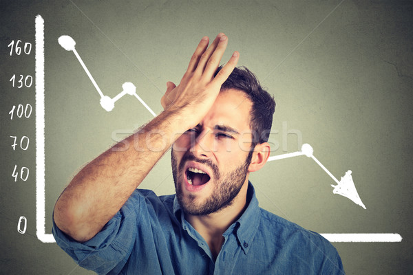 frustrated stressed young man desperate with financial market chart graphic going down Stock photo © ichiosea