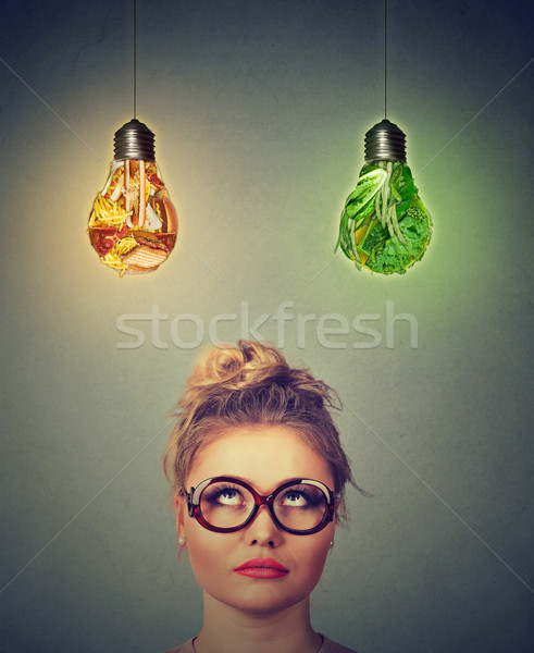 Woman thinking looking up at junk food and green vegetables shaped as light bulb above head  Stock photo © ichiosea