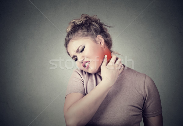 young woman massaging her painful neck colored in red Stock photo © ichiosea