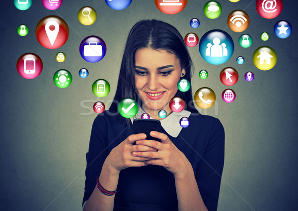 Woman using smartphone with application icons flying out of screen Stock photo © ichiosea