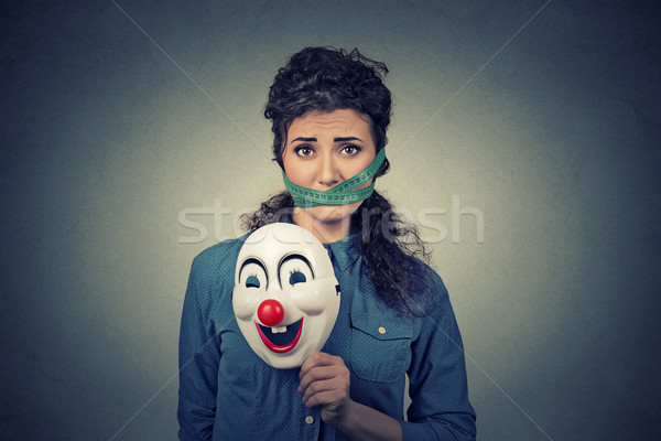 Diet restriction and stress concept. Portrait sad woman with clown mask and measuring tape around he Stock photo © ichiosea