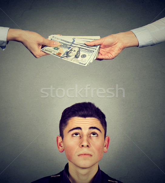 Worried man looking up at two hands exchanging money Stock photo © ichiosea