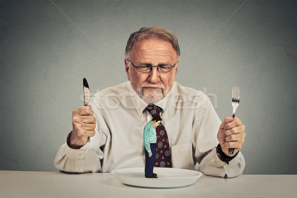 businessman with knife and fork looking at his employee on a plate Stock photo © ichiosea