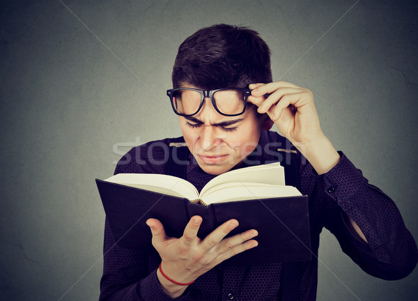 man with eye glasses trying to read book has sight problems Stock photo © ichiosea