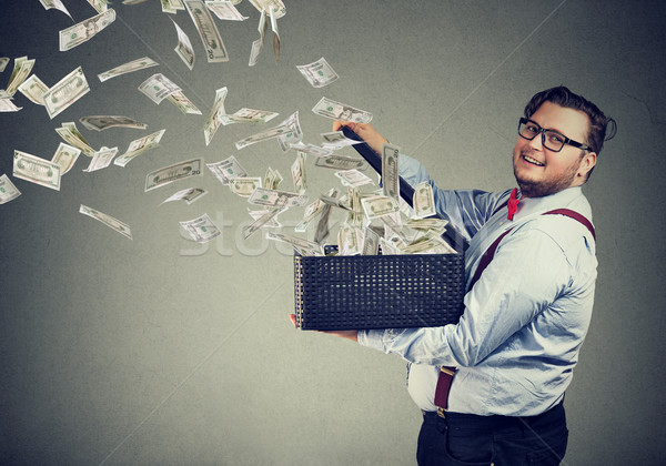 Excited business man opening a box letting dollar banknotes to fly away Stock photo © ichiosea