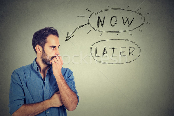 Stock photo: Now or later. Man thinking looking worried anxious making up his mind