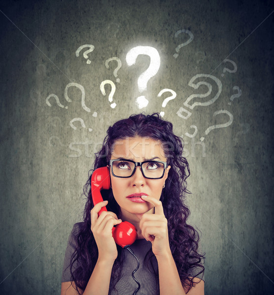 Upset worried confused woman talking on a phone has many questions Stock photo © ichiosea