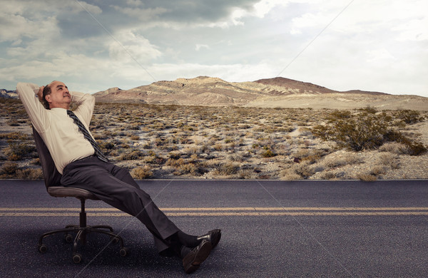 Stock photo: Office worker is lying on a chair outdoors daydreaming 