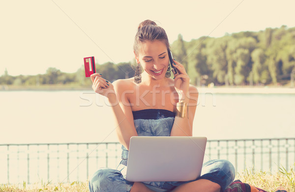 Happy woman shopping on line holding credit card talking on mobile phone  Stock photo © ichiosea