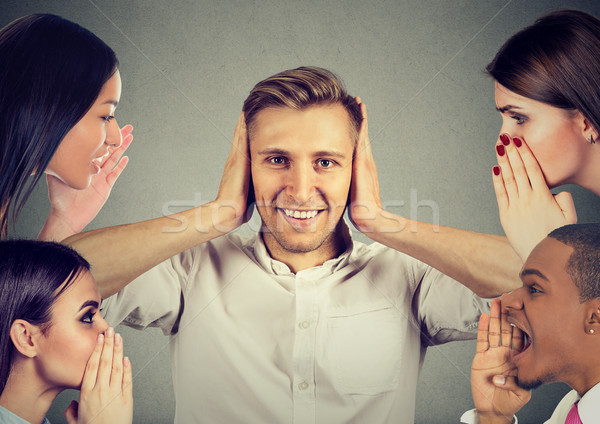 people whispering a secret gossip to a man who covers ears ignoring them  Stock photo © ichiosea