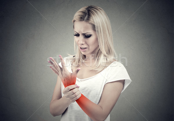 Woman holding her painful wrist. Sprain pain location indicated by red spot. 
 Stock photo © ichiosea