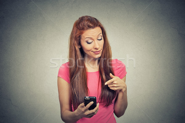 angry woman unhappy, annoyed by something on her cell phone texting Stock photo © ichiosea