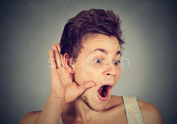 Stock photo: Surprised nosy man hand to ear gesture carefully listening gossip