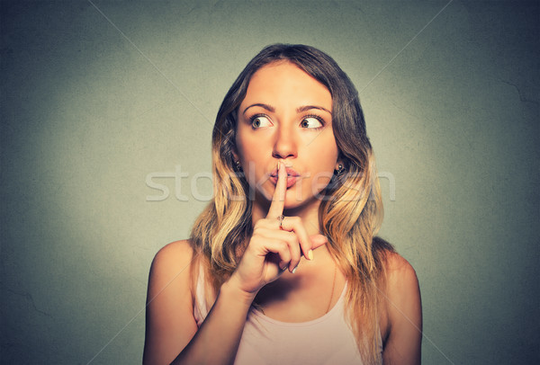 secretive young woman placing finger on lips asking shh, quiet Stock photo © ichiosea