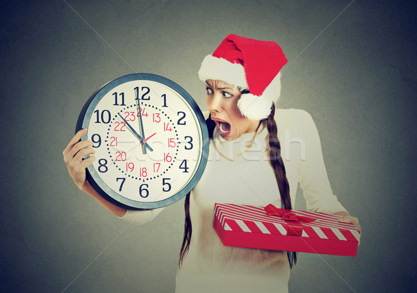 stressed in a hurry woman wearing santa claus hat holding clock gift box Stock photo © ichiosea