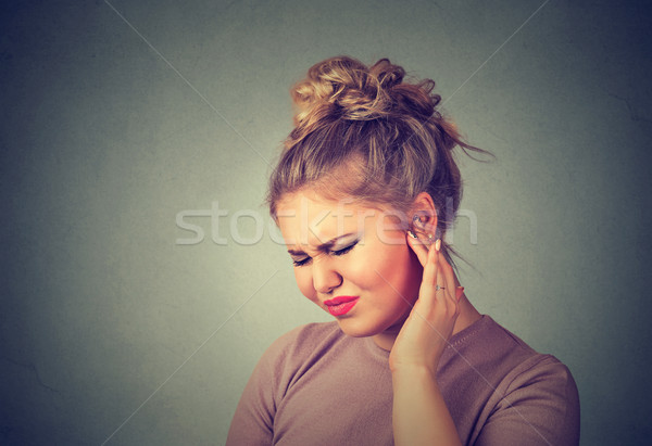 Tinnitus. Sick woman having ear pain touching her painful head  Stock photo © ichiosea