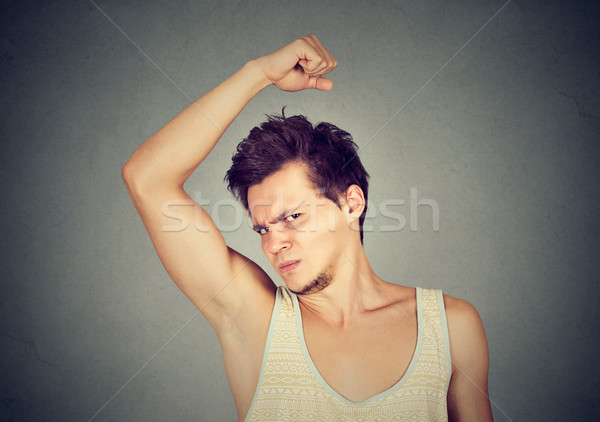 man, smelling, sniffing his armpit, something stinks bad, foul odor  Stock photo © ichiosea