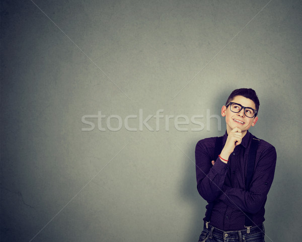 Young happy man leaning on a wall looking up thinking  Stock photo © ichiosea