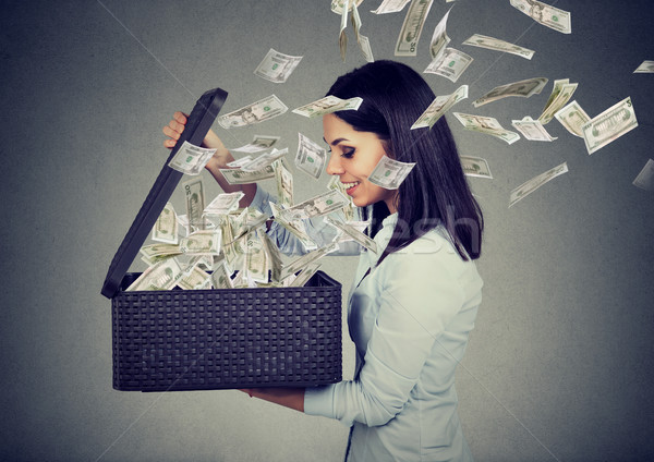 Happy woman opening a box with money flying out away  Stock photo © ichiosea