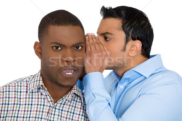 Stock photo: guy whispering something annoying into man's ears