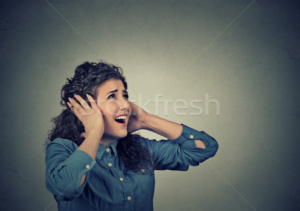 unhappy stressed woman covering her ears looking up stop making loud noise  Stock photo © ichiosea